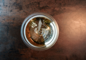 Ansicht eines Getränks von oben im Glas, mit reflektierendem Licht an der Oberfläche.