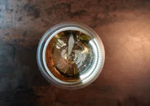 Ansicht eines Getränks von oben im Glas, mit reflektierendem Licht an der Oberfläche.