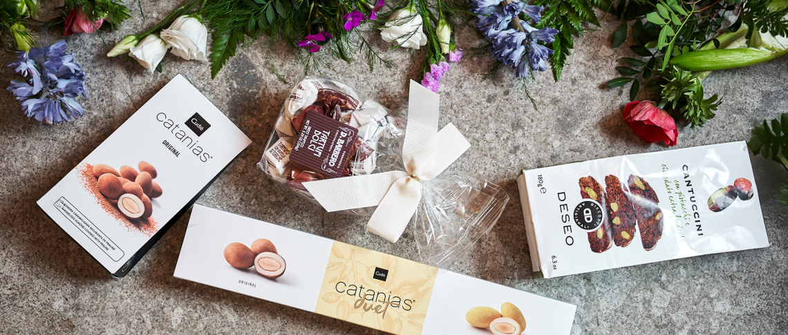 Snack-Verpackungen auf Steinplatte, dekoriert mit bunten Blumenarrangements.