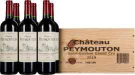 Fünf Weinflaschen mit Etiketten vor einer markanten Holzbox.