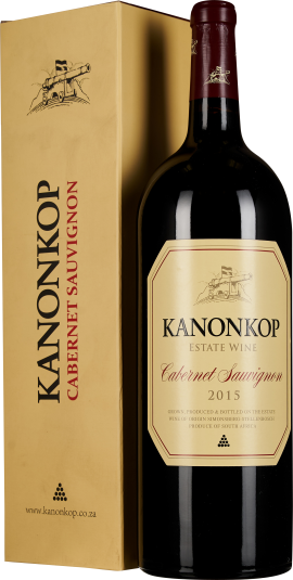 Große Weinflasche mit rotem Etikett, stehend neben einer goldenen Geschenkbox.