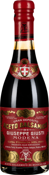 Elegante Balsamico-Flasche mit rotem Etikett und goldenen Verzierungen.
