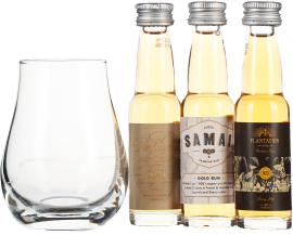 Set aus Whiskyglas und drei Mini-Rumflaschen mit goldener Flüssigkeit.
