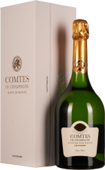 Grüne Weinflasche mit goldener Folie neben eleganter, heller Verpackung.