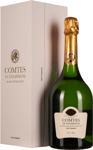 Grüne Weinflasche mit goldener Folie neben eleganter, heller Verpackung.