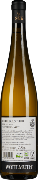 Schlanke Flasche, goldener Wein, schwarzes Etikett mit weißem Text, elegante Präsentation.