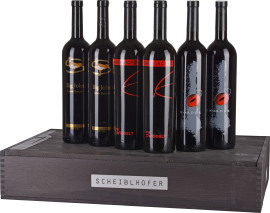 Sechs elegante Weinflaschen auf stilvollem Holzkasten mit markanten Etiketten in Rot und Gold.