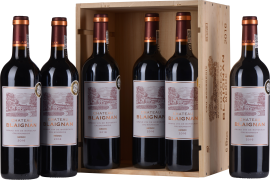 Sechs Bordeaux-Weinflaschen in Holzkiste, elegante Etiketten mit Château-Abbildung.