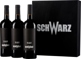 Drei Weinflaschen mit schwarzem Etikett und passender schwarzer Geschenkbox.