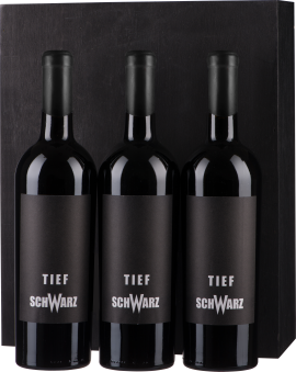 Dunkles Weinset mit drei schwarzen Flaschen in eleganter Verpackung.