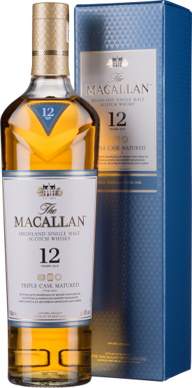 Klares goldenes Destillat in eleganter Flasche neben blauer Geschenkverpackung.