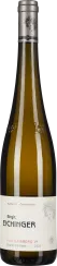 Die Weinflasche hat eine elegante, schlanke Form mit einem silberfarbenen Verschluss. Das Etikett ist überwiegend in Weiß gehalten und zeigt ein feines schwarzes Porträt. Die Flasche schimmert in einem klaren, goldenen Farbton, typisch für Weißwein.