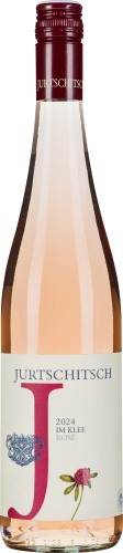 Flasche Roséwein mit klarem, zart rosa Farbton. Etikett mit dekorativen Elementen, darunter ein großes rotes "J", blaue Verzierungen und eine kleine Blume. Verschluss in dunklem Rot gehalten.