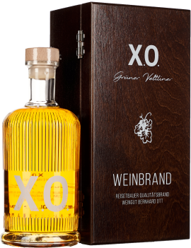 Eine elegante Flasche mit goldenem Destillat, versehen mit vertikalen Rillen und einem Holzverschluss, steht neben einer dunkelbraunen, edlen Holzbox.