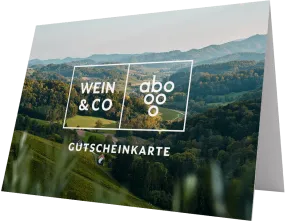 Gutscheinkarte mit einem idyllischen Landschaftsfoto, das sanfte Hügel und üppige Wälder zeigt, unter einem klaren Himmel. Auf der Vorderseite sind stilisierte weiße Schriftzüge platziert.