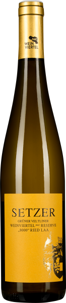 Braune Weinflasche mit gelbem Etikett, schwarzem Schriftzug und goldener Kapsel.