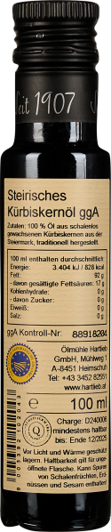 Schwarze Flasche mit naturfarbenem Etikett, weiße Schrift, „Seit 1907“ auf Deckel.