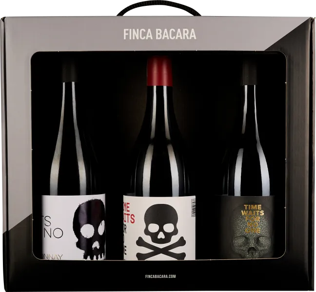 Drei Weinflaschen in schwarzer Box mit Totenkopf-Design auf Etiketten.