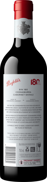 Weinflasche mit roter Kapsel, silbernem Wappen und detailliertem weißen Etikett.