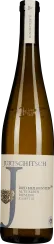 Eine schlanke, braune Weinflasche mit einer weißen Etikettierung, die einen eleganten, minimalistischen Stil zeigt. Die Flasche ist von einem schlichten metallischen Emblem und einem großen, stilisierten Buchstaben in der Mitte des Etiketts geziert.