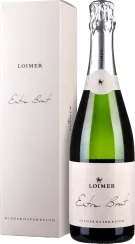 Eine Sektflasche mit grünem Glas, silberner Folienkapsel und einem cremefarbenen Etikett. Daneben steht eine farblich passende Box.