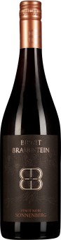 Dunkle Weinflasche mit bronzefarbenem Schraubverschluss. Das Etikett ist dunkelbraun mit goldener und kupferner Schrift und zeigt ein stilisiertes Logo.