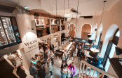 Elegante Weinbar mit hohen Decken, stilvollen Lampen und geselligem Ambiente.